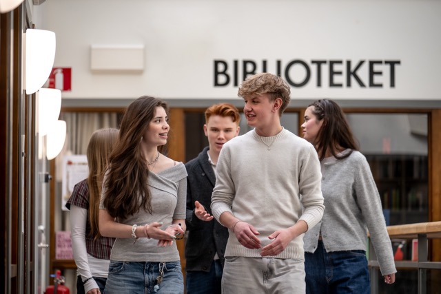 Flera elever går förbi biblioteket i skolan
