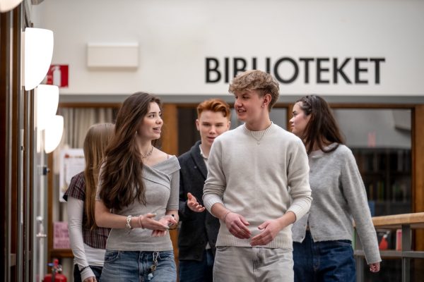 Flera elever går förbi biblioteket i skolan