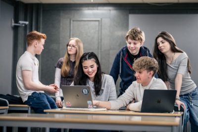 Elever som hänger i klassrum och diskuterar