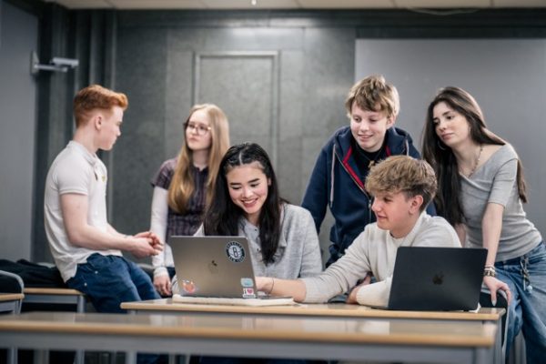 Elever som hänger i klassrum och diskuterar